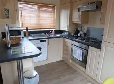 a kitchen with a sink and a stove top oven at Rosewater Park Lodge in Bodmin