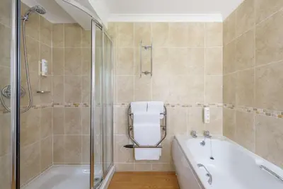 a bathroom with a shower and a tub and a sink at Best Western Fowey Valley in Lostwithiel