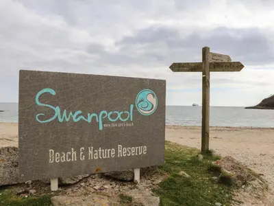 a sign on the beach next to the ocean at Lake View in Falmouth
