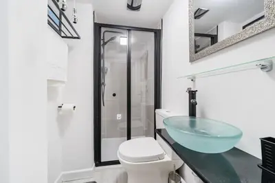a bathroom with a glass sink and a toilet at Fowey, Cute Cottage in Fowey