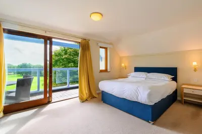 a bedroom with a bed and a large window at Golf View 80 in Camborne
