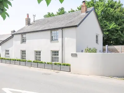 a white house on the side of a street at Cob Cottage in Wadebridge