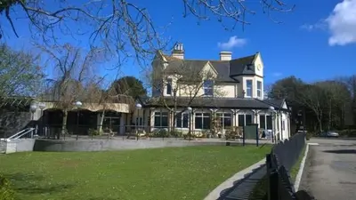 a large white house with a lawn in front of it at Tolroy Manor - 84 Strawberry Hill in Hayle