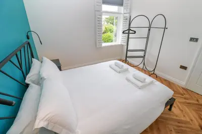 a bedroom with a bed with two white towels on it at St Piran in St Ives