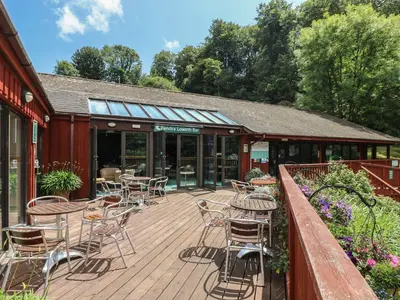 a wooden deck with chairs and tables on a building at Jaspers Retreat, formerly known as Starfish Cottage in Falmouth