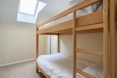 a bunk bed room with two bunk beds and a window at Clowance, Golf View 80b in Praze an Beeble