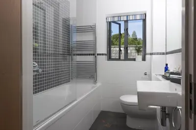 a bathroom with a toilet and a shower and a sink at Landing View Fowey Penthouse in Fowey