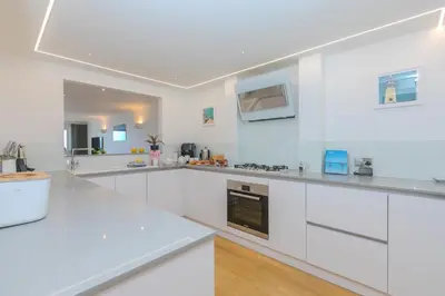 a white kitchen with white counters and appliances at Viridian in Carbis Bay