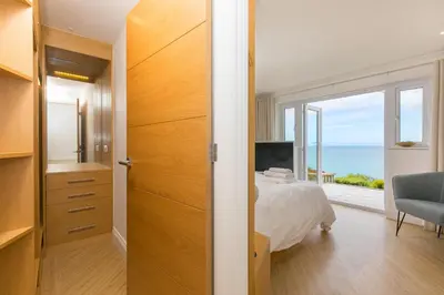 a bedroom with a bed and a view of the ocean at Viridian in Carbis Bay
