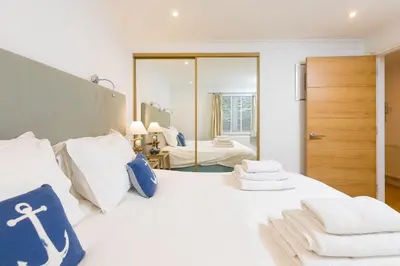 a bedroom with a white bed with towels on it at Viridian in Carbis Bay