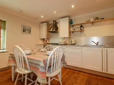 a kitchen with a table and chairs in a kitchen at 6 Trelawney Court in Wadebridge