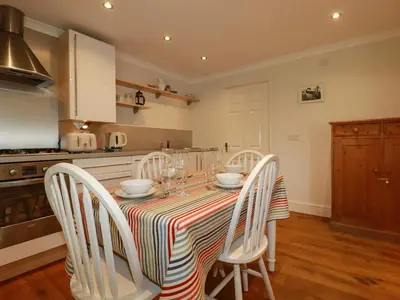 a kitchen with a table with four chairs and a kitchen at 6 Trelawney Court in Wadebridge