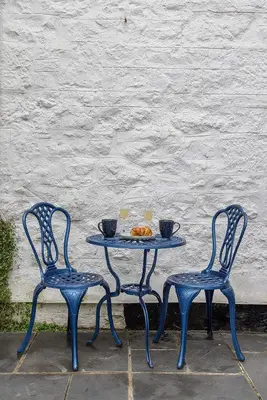 two blue chairs and a table with two cups on it at St Ives apartment less than 5 minutes walk to beach parking available in St Ives