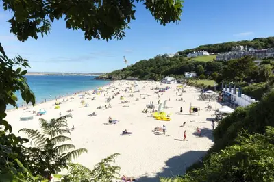 a beach with a lot of people on it at St Ives apartment less than 5 minutes walk to beach parking available in St Ives