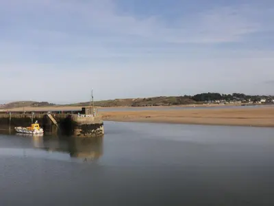 a boat in the water next to a pier at Polwen in Padstow