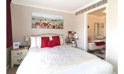 a bedroom with a white bed with red pillows at Seven Bed and Breakfast in St. Agnes