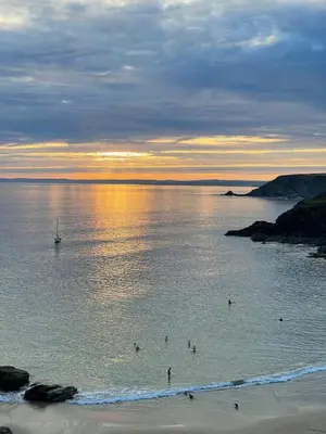 a group of people in the water at the beach at The Garden Room - Cabin on The Lizard in Cury