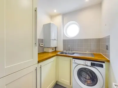 a kitchen with a washing machine and a sink at Cornwall Truro Falmouth cottage in Perranwell