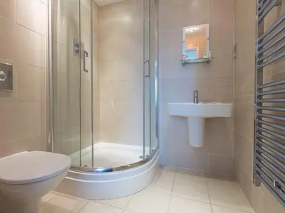 a bathroom with a shower and a toilet and a sink at Sea Bleu in St Ives