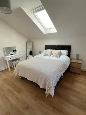 a bedroom with a large bed with a skylight at The Boathouse in Mylor Bridge