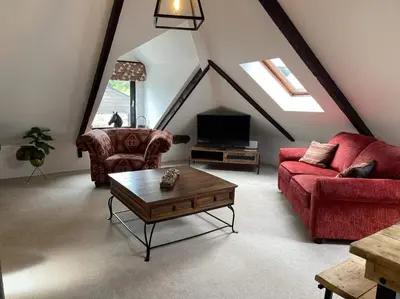a living room with a red couch and a coffee table at Stunning 4 Bed Pet Friendly Cottage with Hot Tub in Bodmin