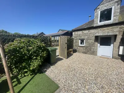 a stone house with a white door and a fence at Stunning 4 Bed Pet Friendly Cottage with Hot Tub in Bodmin