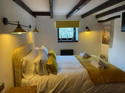 a bedroom with a large bed with yellow pillows at Stunning 4 Bed Pet Friendly Cottage with Hot Tub in Bodmin