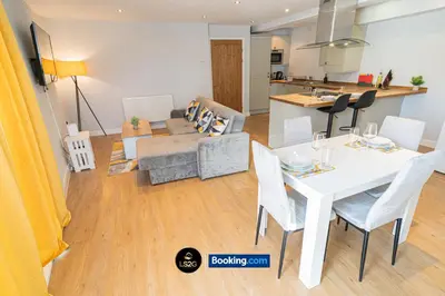 a living room and kitchen with a white table and chairs at Spacious 2 Bedroom Flat By LS2G Short Lets & Serviced Accommodation Greater London With Free WIFI in Newquay