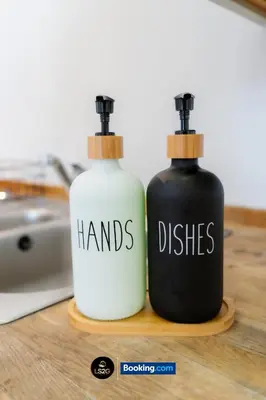 two bottles of hands and dishes sitting on a table at Spacious 2 Bedroom Flat By LS2G Short Lets & Serviced Accommodation Greater London With Free WIFI in Newquay