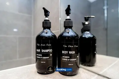 three bottles sitting on a counter in front of a mirror at Spacious 2 Bedroom Flat By LS2G Short Lets & Serviced Accommodation Greater London With Free WIFI in Newquay