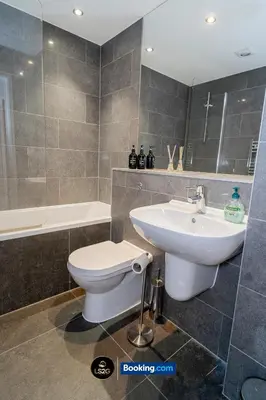 a bathroom with a toilet and a sink and a tub at Spacious 2 Bedroom Flat By LS2G Short Lets & Serviced Accommodation Greater London With Free WIFI in Newquay