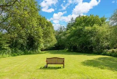 a park bench sitting in the middle of a field at Honey Pot in Liskeard