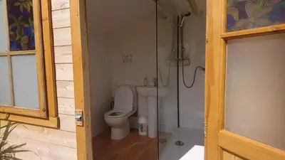 a bathroom with a toilet and a shower at Tiny House Glamping, sleeps up to 6 in Gweek