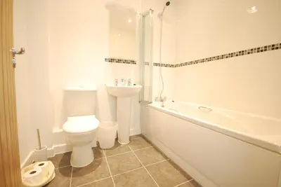 a bathroom with a toilet and a tub and a sink at Anemone in Porthtowan