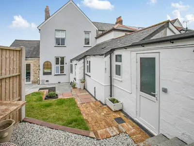 a white house with a garage and a yard at Lanner Moon in Carnbrea