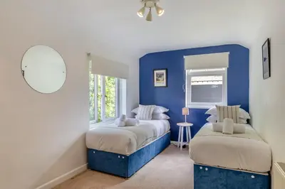 a blue bedroom with two beds and a window at 5 Bed in Bodmin oc-l29658 in Blisland