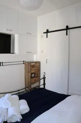 a bedroom with a bed with a microwave and towels at Flip Flop Flat, Sea Views, Short Stroll to Beaches in Newquay