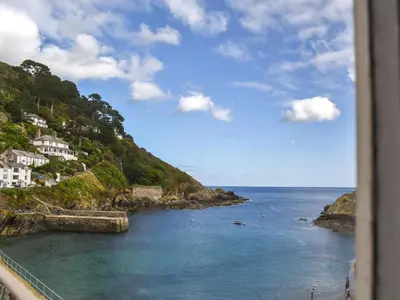 a view of the ocean with houses on a hill at Charlie Wilcox Cottage in Polperro
