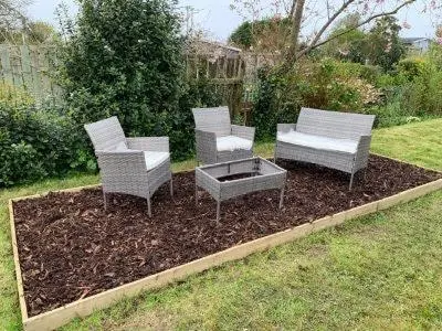 three chairs and a fire pit in a yard at Fowey, quaint cottage near sea in Fowey