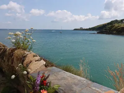 a view of a body of water with flowers at Chy Rani in Portmellon