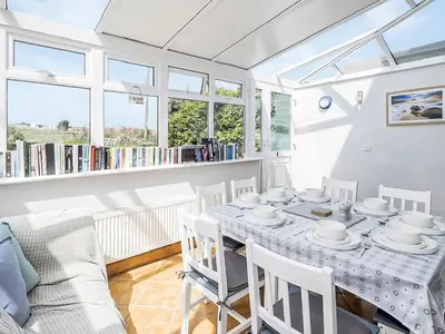 a dining room with a table and chairs at The Light House in Gwithian