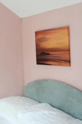 a bed in a room with a picture on the wall at Wee Cott in Hayle