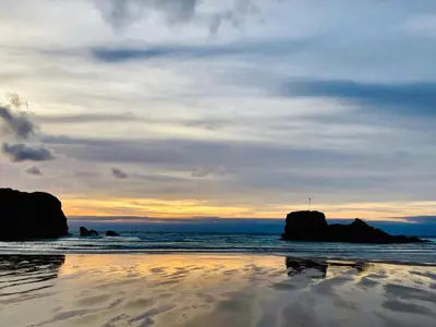 a sunset on a beach with rocks in the water at Pool - Fireplace - 2Br Lodge - PetsOK - Parking in Newquay