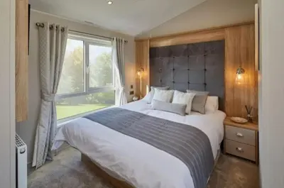a bedroom with a large white bed and a window at Pool - Fireplace - 2Br Lodge - PetsOK - Parking in Newquay