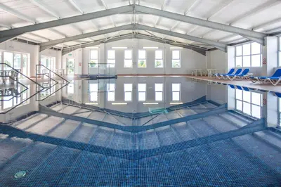 a large swimming pool with blue chairs in it at Pool - Fireplace - 2Br Lodge - PetsOK - Parking in Newquay