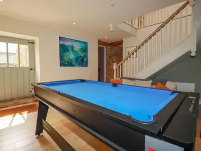 a pool table in a living room with a staircase at The Old Watermill in Bodmin