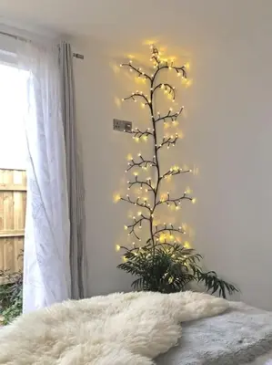 a christmas tree with lights on a wall at The Cuckoo's Nest - A Romantic & Peaceful Hideaway in Kenwyn