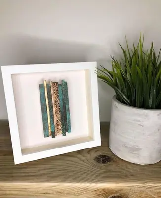 a picture frame sitting on a table next to a plant at The Cuckoo's Nest - A Romantic & Peaceful Hideaway in Kenwyn