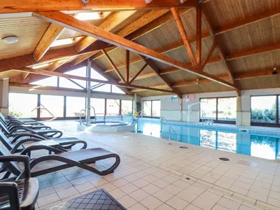 a swimming pool with a row of chairs in a building at Bay View in Redruth