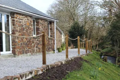 a stone house with rope around a yard at The BarnsPigallie in Redruth